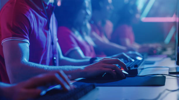 diverse esport team of pro gamers playing in video game on a championship. focus on hands, keyboards and mouse. stylish neon cyber games arena. online tournament event. - esport audience bildbanksfoton och bilder