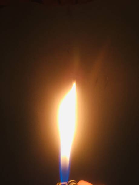 istock The bright light of a mancis fire lit in a dark room. 1357436515