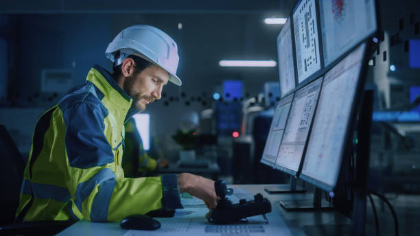 istock Industry 4.0 Modern Factory: Female Facility Operator Controls Workshop Production Line, Uses Computer with Screens Showing Complex UI of Machine Operation Processes, Controllers, Machinery Blueprints 1357436646