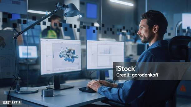 Industrial Engineer Solving Problems Working On A Personal Computer Two Monitor Screens Show Cad Software With 3d Prototype Of Ecofriendly Electric Engine Concept Stock Photo - Download Image Now