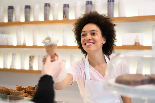 istock Happy woman working at an ice cream parlor 1357437652