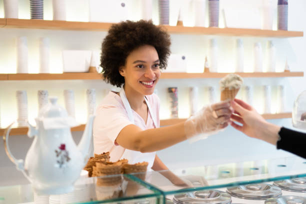 istock Happy woman working at an ice cream parlor 1357437693