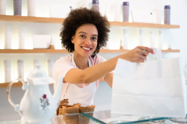istock Happy woman working at an ice cream parlor 1357437937