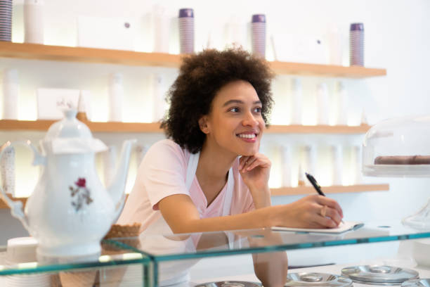 istock Happy woman working at an ice cream parlor 1357437963