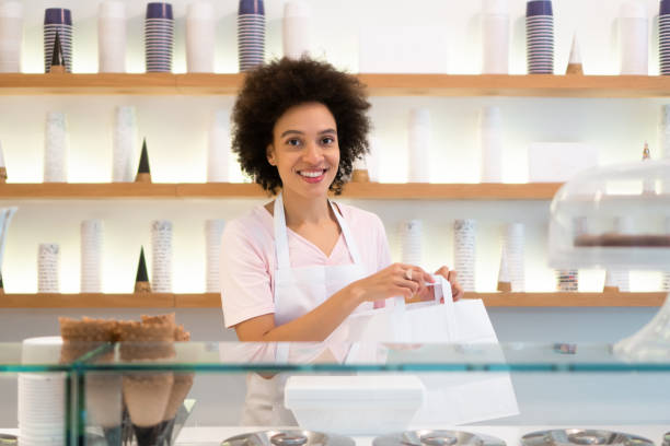 istock Happy woman working at an ice cream parlor 1357437969