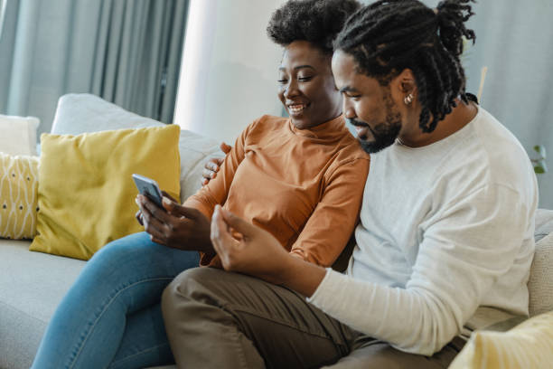 istock Young couple using mobile phone at home 1357438119