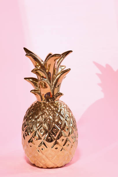 istock Golden pineapple for home decor on pale pink background 1357438243