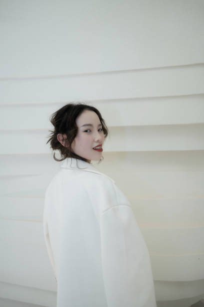 Asian girls in white coats play under empty, simple buildings