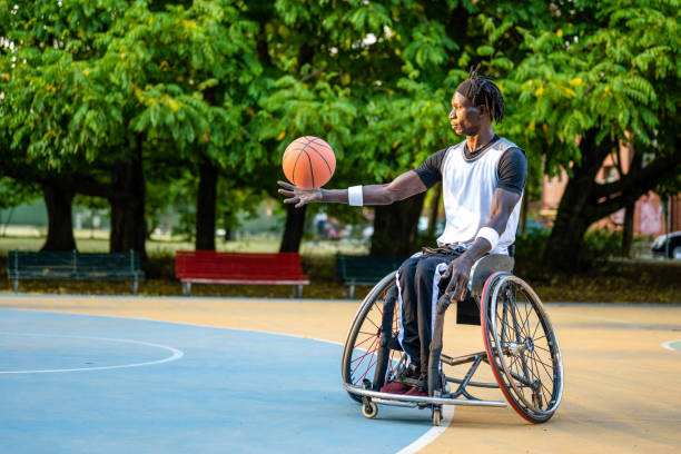 basketball-athlet im rollstuhl, afroamerikanischer mann mit behinderungen beim sport im freien, copy space - men chair wheelchair sport stock-fotos und bilder