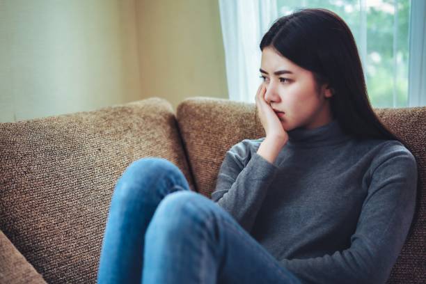 malheureuse jeune femme asiatique assise seule se sentant mal, fille émotive déprimée. - sexual violence photos et images de collection