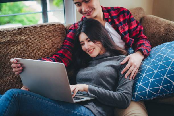 istock asian couple relaxing using tablet computer on vacation together at home, People lifestyle concept. Christmas or anniversary. 1357443348