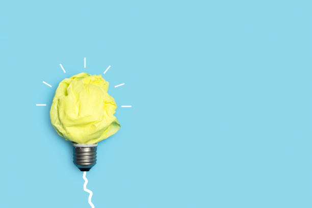 istock Light bulb made with yellow crumpled paper on a white background 1357447917
