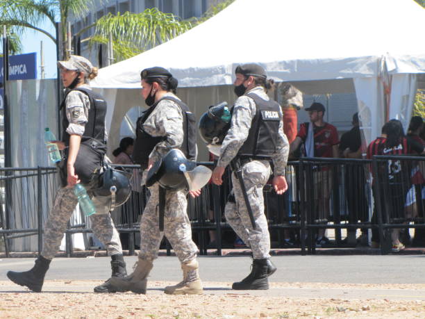 Centenario Stadium Final soccer Copa Conmebol Sudamericana 2021 Atletico Paranaense vs Bragantino. Police guard the entrance to the soccer field. The historic concrete stadium built in 1930 with modern architecture is the place where Brazilian football teams play the final in Montevideo Uruguay. Security is protected by the police. Clear sunny day in the stadium. Fans, Police, security. Montevideo, Uruguay. south american football confederation stock pictures, royalty-free photos & images