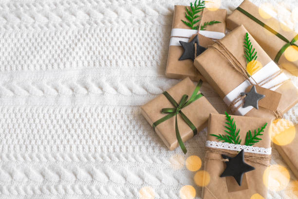 Vintage gift boxes on white background. Eco style gift wrapping: natural rough paper, jute rope, gift signing labels, branches of a christmas tree for decor. Top view, copy space. stock photo