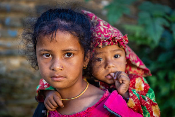Nepali girls holding her little brother, village near Annapurna Range Nepali girls holding her little brother outside her parents house, village in Annapurna Conservation Area. central asian ethnicity stock pictures, royalty-free photos & images