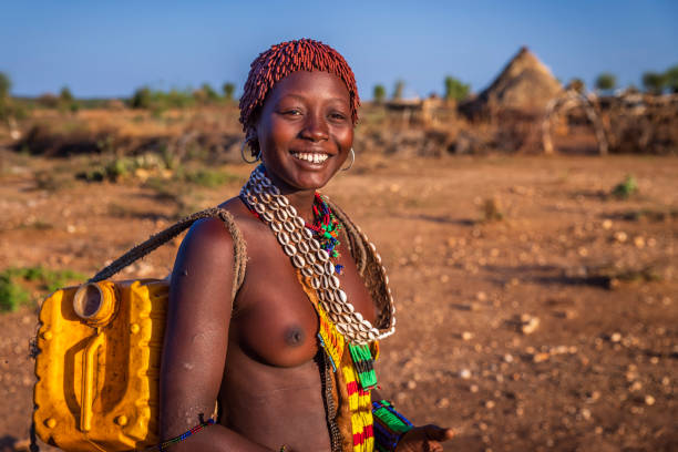 jovem africana carregando água do poço, etiópia, áfrica - women indigenous culture africa ethiopia - fotografias e filmes do acervo