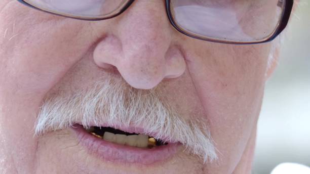 istock An elderly grandfather with a gray mustache and glasses is talking, 1357454762