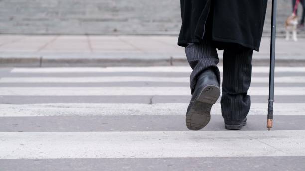 istock A man crosses the street with a stick. 1357456266
