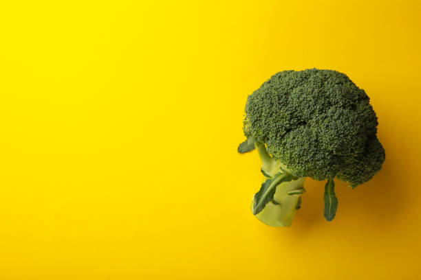 istock Broccoli cabbage on a yellow background. Pattern of fresh broccoli cabbage. 1357460232