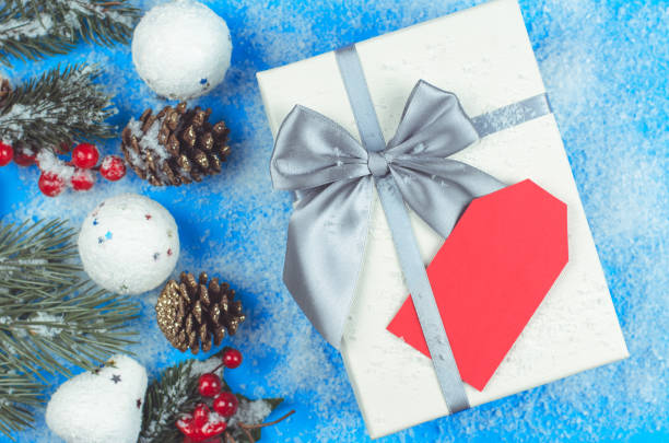 istock Mockup for Christmas greetings or invitations. Blank red label on a white gift box. 1357460861