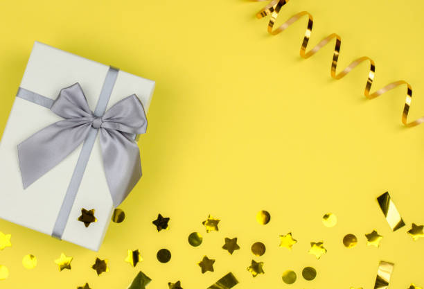 istock Gift box on a yellow background with sequins and serpentine, copy space. 1357460951