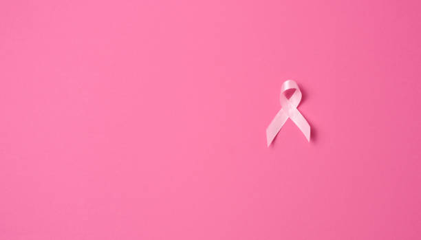 istock pink silk ribbon in the form of a loop on a pink background. 1357460960