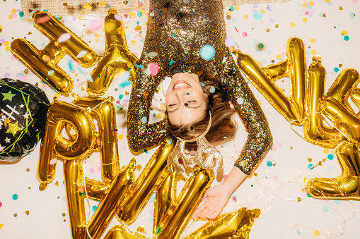 Photo of a young woman lying down on the floor after the New Year's Eve party