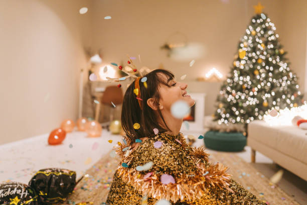 istock Smiling woman sitting on the floor while confetti is falling 1357461482