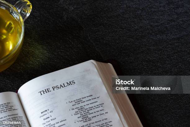 Open Holy Bible With Cup Of Tea On Dark Granite Background With Copy Space For Text Stock Photo - Download Image Now