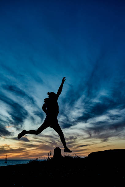 Sport woman doing workout routine with beach on background - Focus on female silhouette