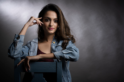 Young Indian female model wearing denim wear and maroon crop top