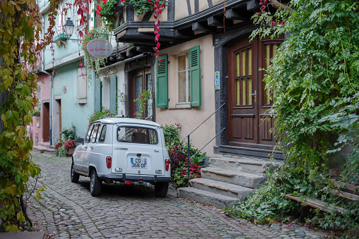 Eguisheim, France - October 24, 2021: Renault 4 classic car parked in Eguisheim cobblestone street, historic village sits on the Alsace region in Eastern France