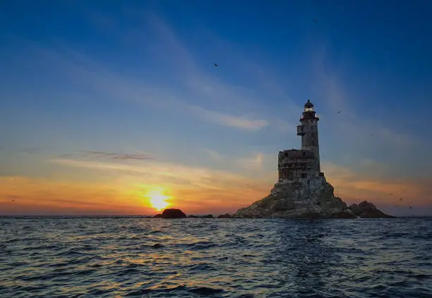 Aniva - The abandoned lighthouse Aniva in the Sakhalin Island,Russia. View from the boat in the sea while sunset.