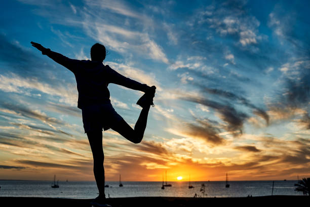 istock Happy woman doing workout routine at sunset with beach on background - Focus on female silhouette 1357464389