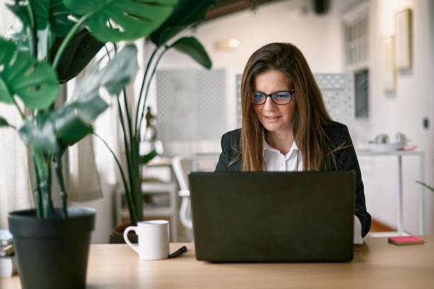istock Mature business woman using laptop computer inside modern office - Focus on face 1357466299