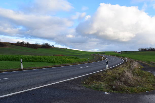 istock country road curve between winter green fields 1357469690