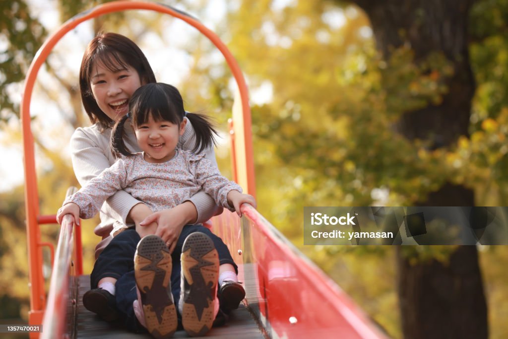 Parents and children playing on the slide Child Stock Photo
