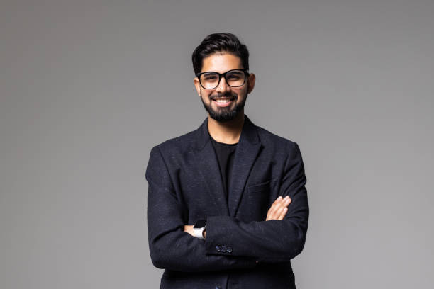 istock Smiling young business man holding hands crossed, looking aside posing isolated on grey background. 1357472196