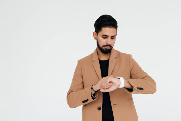 istock Indian young business man looking at watch over white background 1357472387