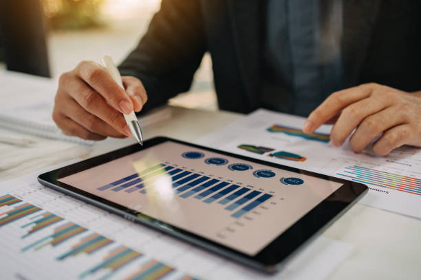 istock businessman working on project for analyzing company financial statistic result with smart device at modern office space. Concept for business, economy and tax. 1357475668