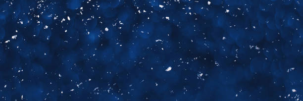 istock Blue sparkling glitter bokeh background with white snow banner 1357478737
