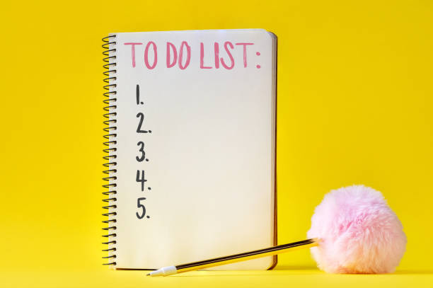 cuaderno con lista de tareas y bolígrafo con bola esponjosa sobre fondo amarillo - spiral notebook spiral ring binder blank fotografías e imágenes de stock