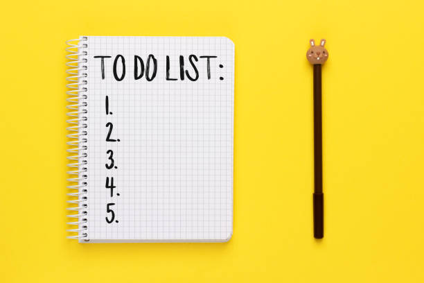 istock Notebook with to do list and pen on yellow background 1357479138