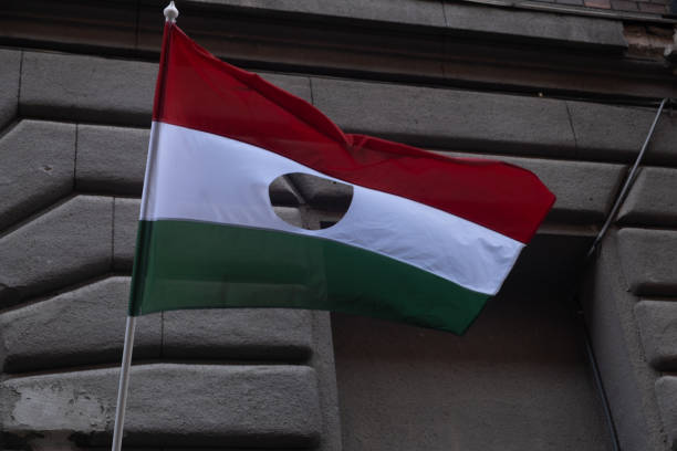 bandera nacional húngara con agujero al aire libre, bandera de hungría - hungarian flag fotografías e imágenes de stock