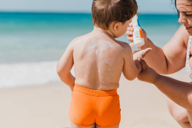 istock Mother putting sunscreen cream to toddler son 1357488437