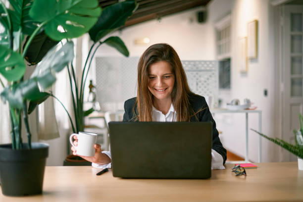 istock Happy business woman using laptop computer inside modern office - Focus on face 1357491003
