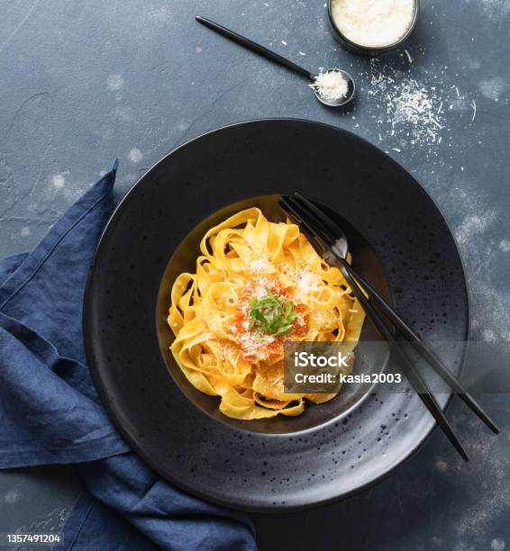 Fettuccine Pasta With Traditional Italian Passat Sauce And Parmesan Cheese In Black Plate On Dark Background Top View Stock Photo - Download Image Now