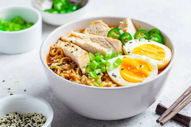 Asian noodle soup ramen with chicken and egg in a gray bowl. Japanese food concept.