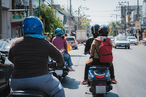 Group of motorbike or scooter rider commuting on a City Street in Khon Kaen at Thailand