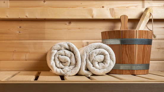 Detail from buckets and white towels in a sauna, wellness accessories.